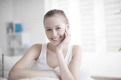 portrait of a handsome young woman sit on a couch in her living Free Download portrait of a handsome young woman sit on a couch in her living - GFXLoad