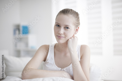 portrait of a handsome young woman sit on a couch in her living