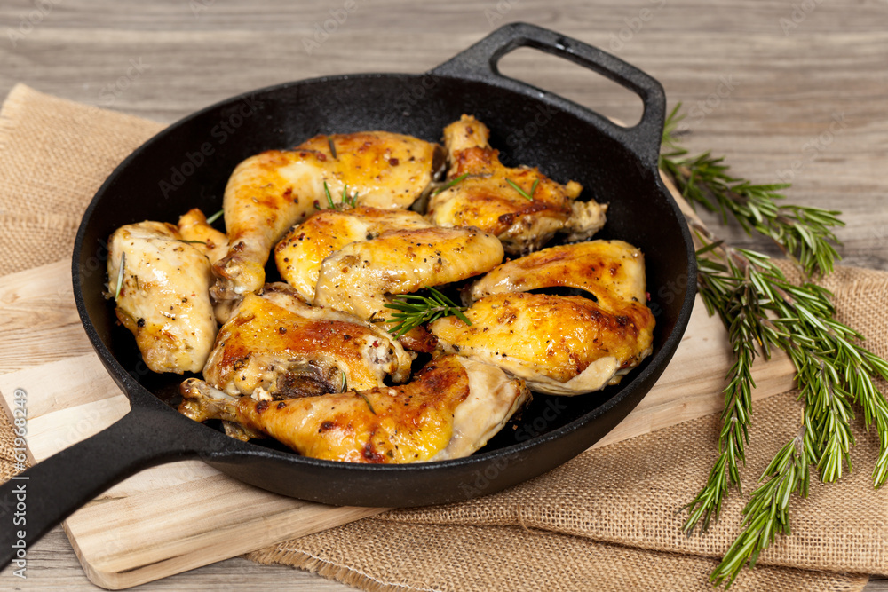 Frying pan with chicken, garlic and rosemary Frying pan with chicken, garlic and rosemary