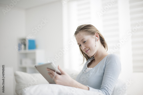 beautiful young woman listening to music on a digital tablet sit