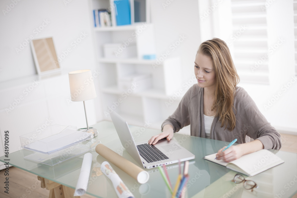 beautiful young woman working on her laptop in her office beautiful young woman working on her laptop in her office