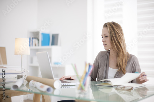beautiful young woman working on her laptop in her office