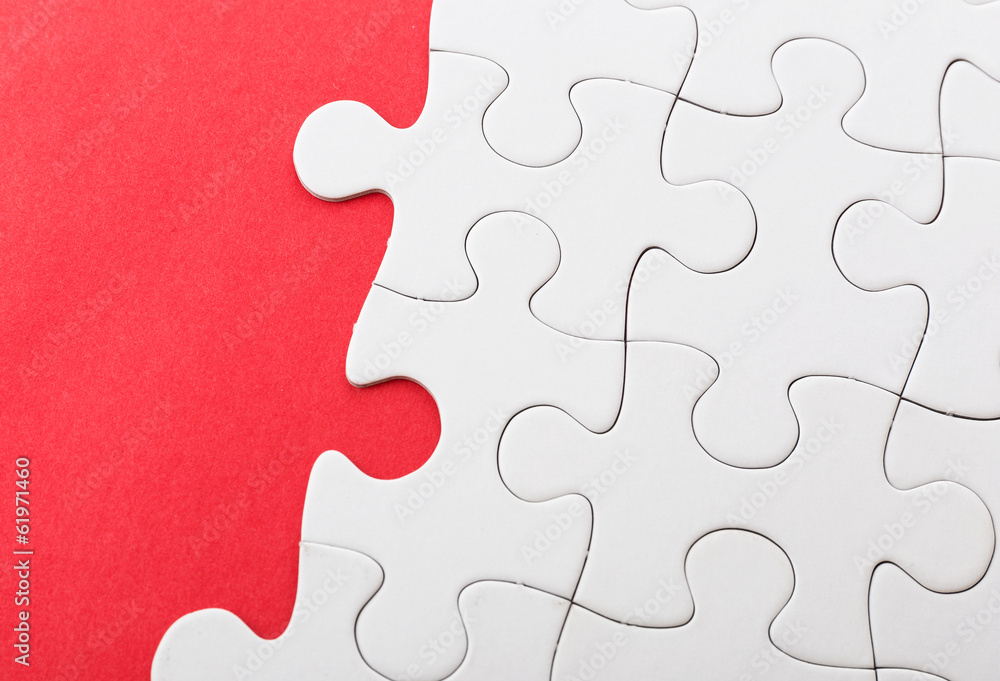 Unfinished puzzle over red background Unfinished puzzle over red background