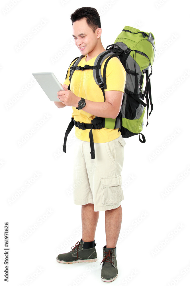 male hiker with backpack using tablet computer male hiker with backpack using tablet computer