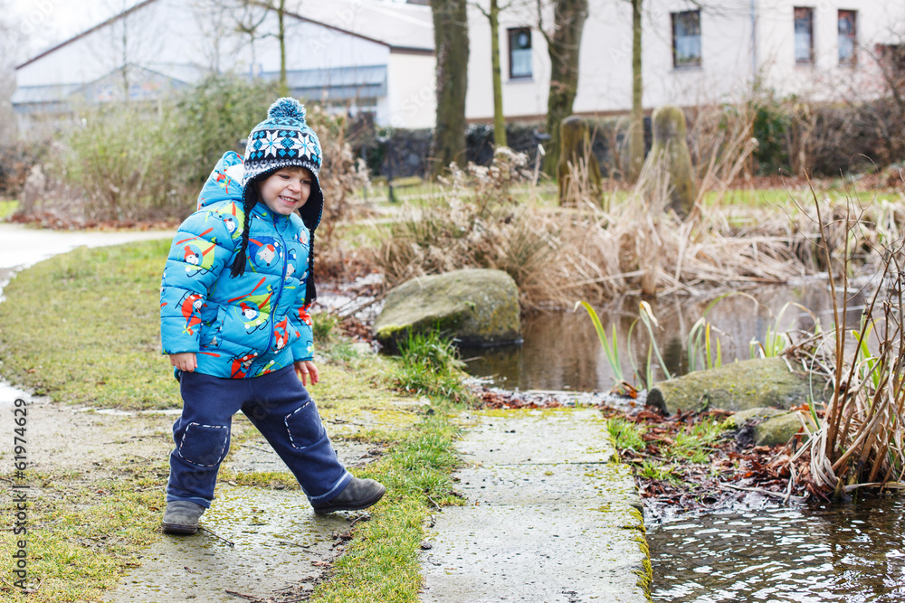 Portrait of cute caucasian toddler boy in warm clothes on cold d Portrait of cute caucasian toddler boy in warm clothes on cold d