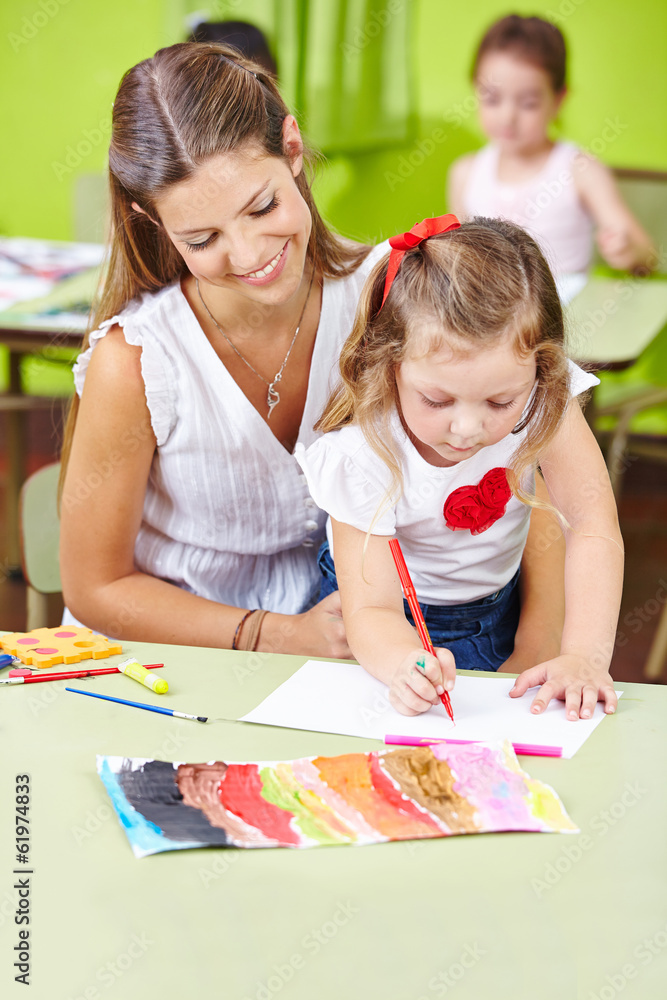 Fototapeta premium Tagesmutter malt mit Kindern