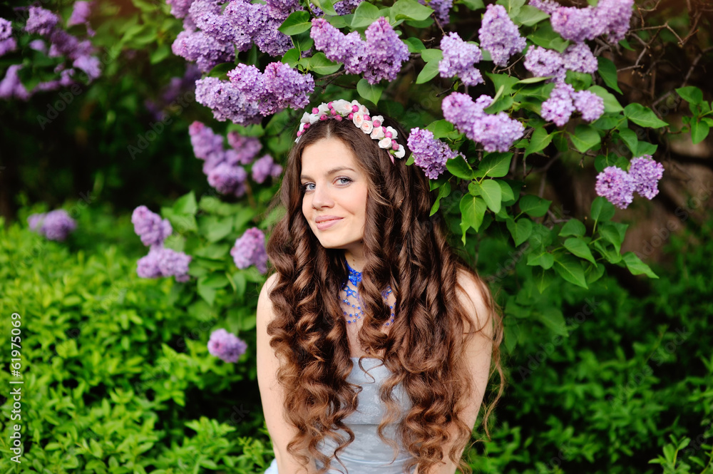 Beautiful young woman in lilac flowers, outdoors portrait Beautiful young woman in lilac flowers, outdoors portrait