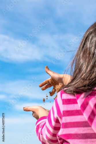 Hands of child full of wet sand