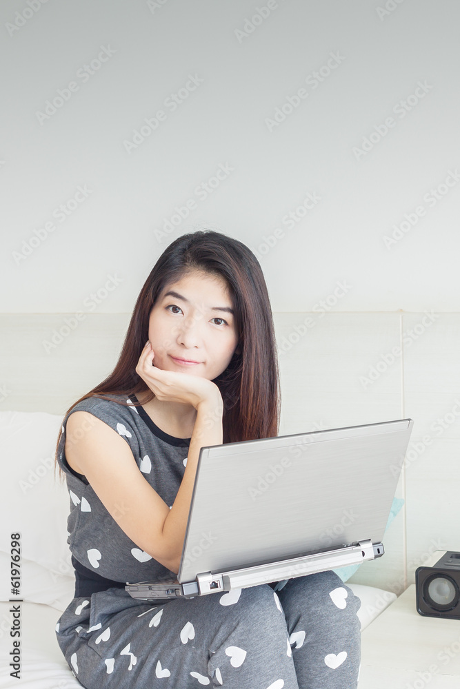 Young Asian woman playing internet on notebook and smile Young Asian woman playing internet on notebook and smile