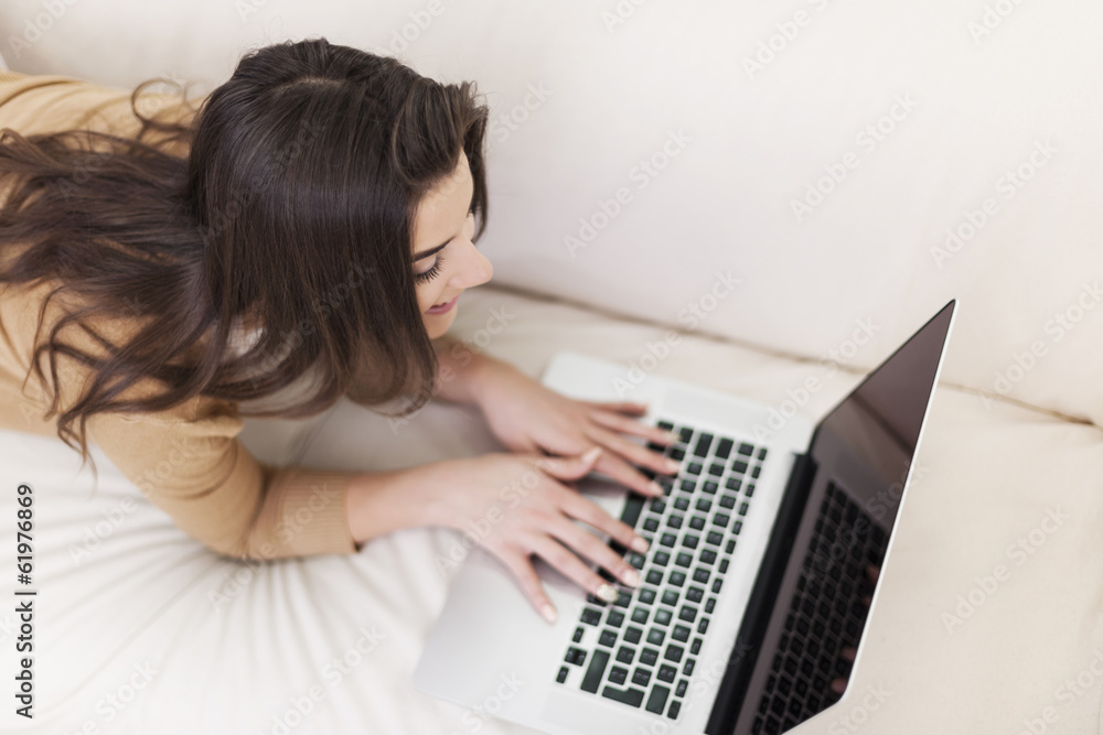Woman enjoying free time with laptop on sofa Woman enjoying free time with laptop on sofa