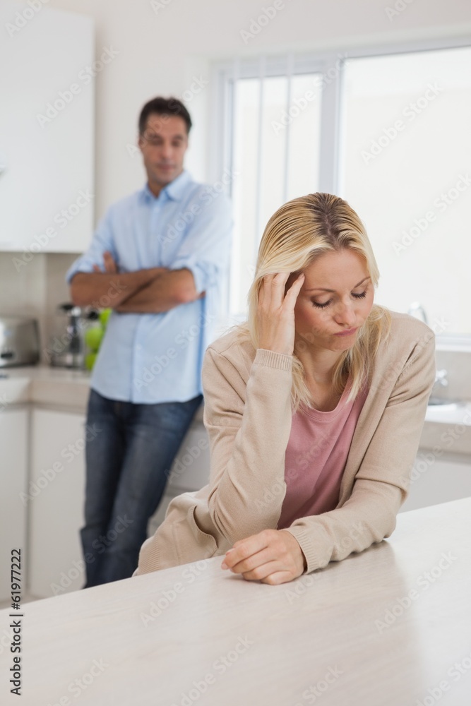 Couple not talking after an argument in kitchen Couple not talking after an argument in kitchen