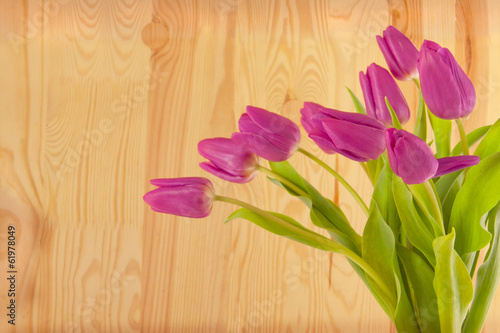 Purple tulips bouquet isolated on wooden background. 