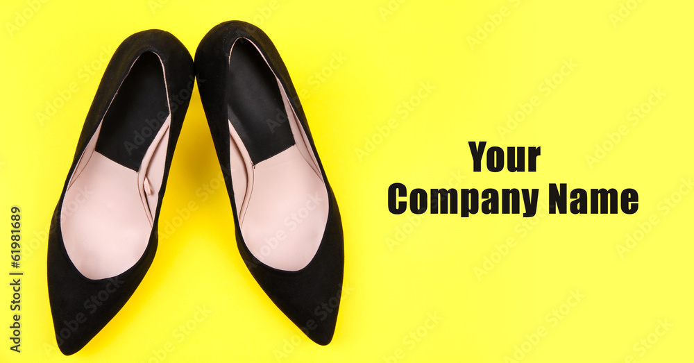 Beautiful black female shoes, on yellow background Beautiful black female shoes, on yellow background