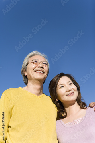senior husband and wife looking up the sky with smile