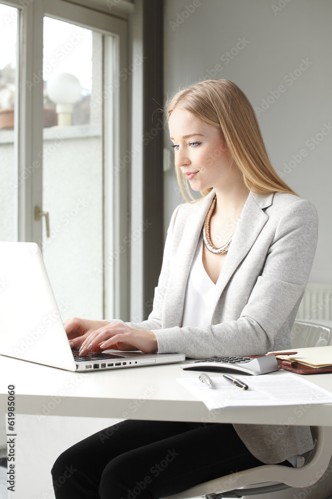 Portrait of beautiful businesswoman working on laptop
