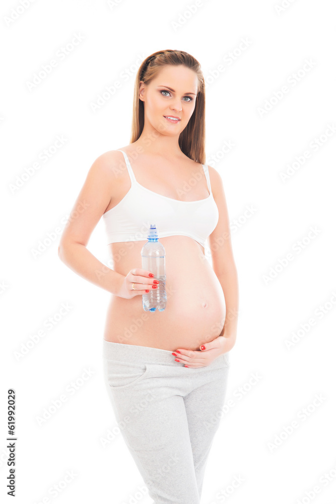 A young pregnant woman holding a bottle of fresh water A young pregnant woman holding a bottle of fresh water
