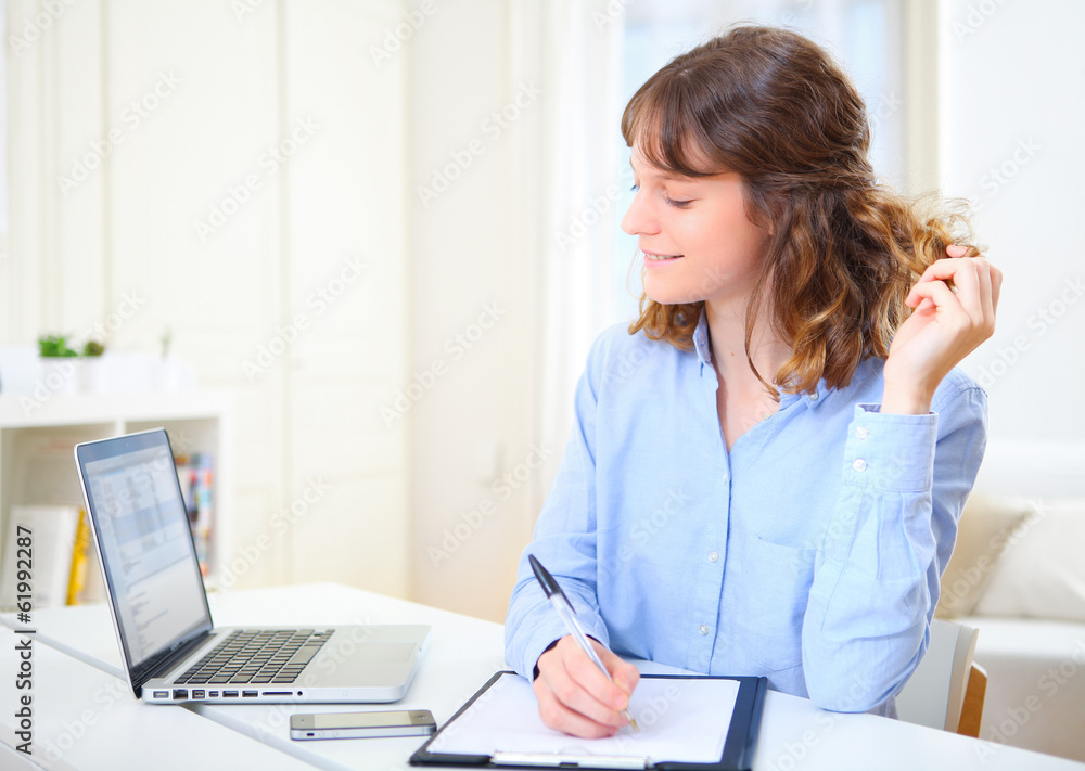 Young attractive business woman copying data on paper Young attractive business woman copying data on paper