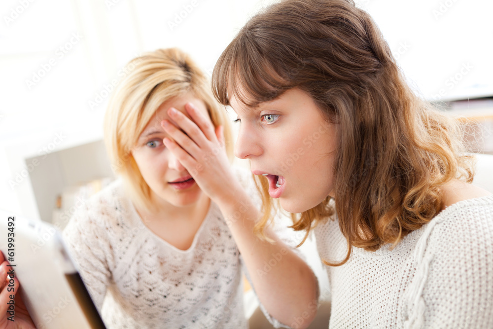 Girls learning important news reading on tablet Girls learning important news reading on tablet
