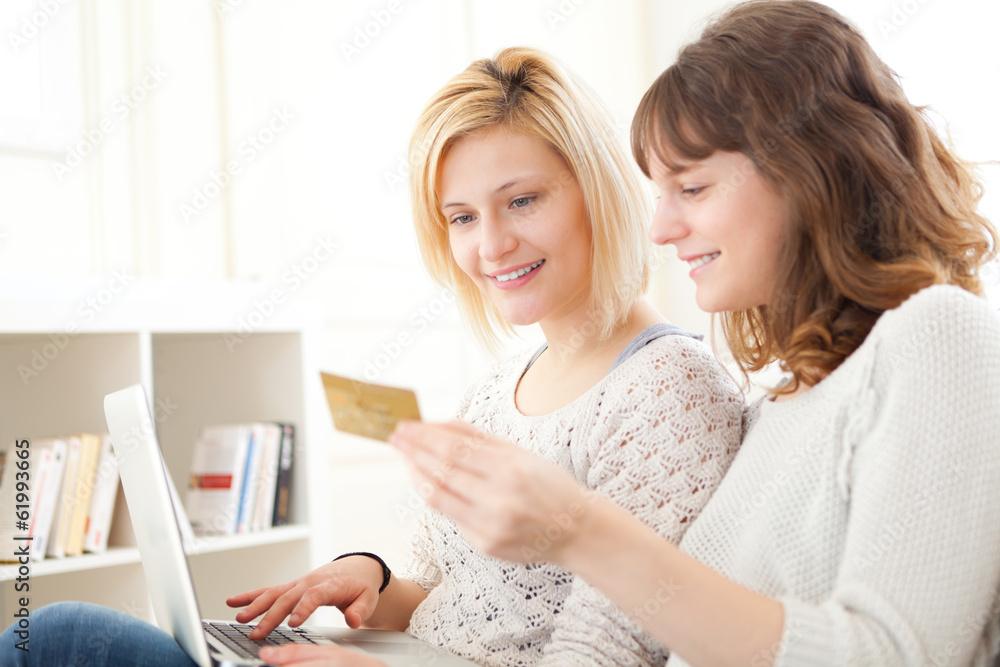 Girls paying with credit card on their computer Girls paying with credit card on their computer