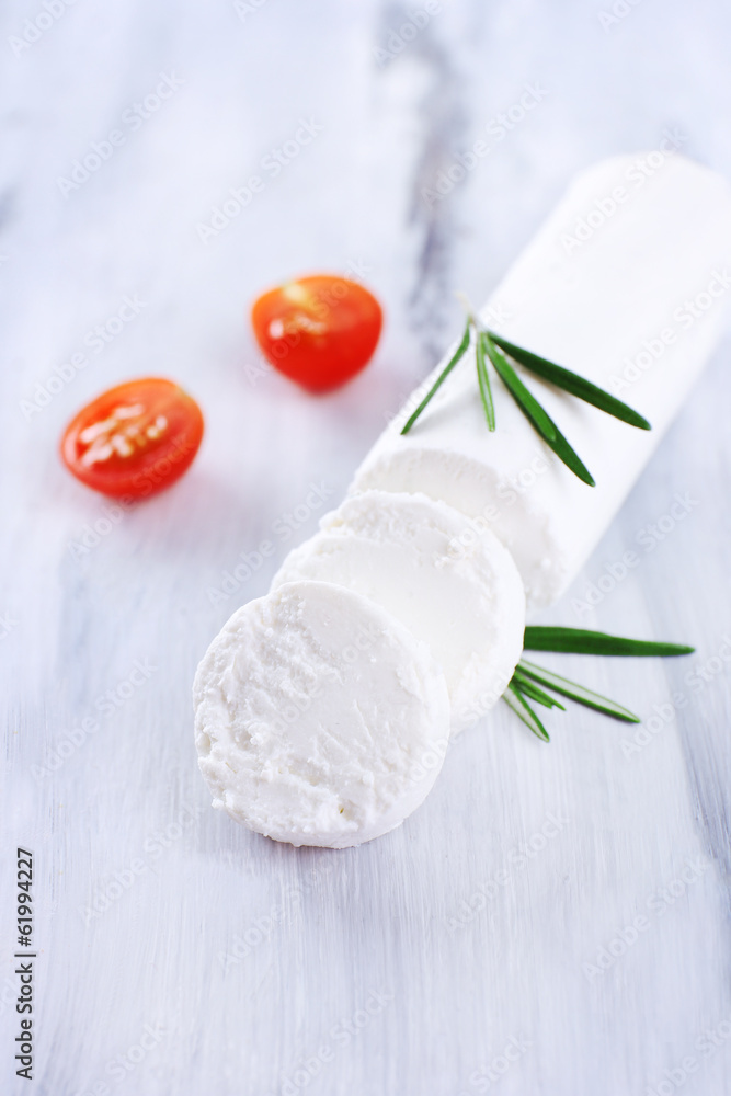 Tasty bushe cheese with rosemary and tomatoes, on wooden table Tasty bushe cheese with rosemary and tomatoes, on wooden table