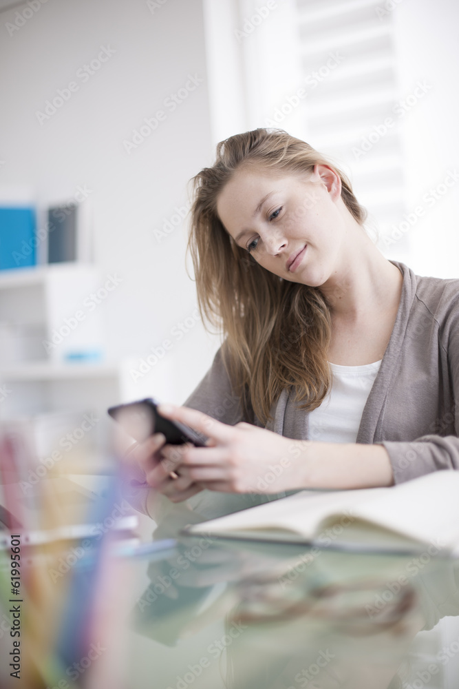 beautiful young woman on the workplace using his phone beautiful young woman on the workplace using his phone