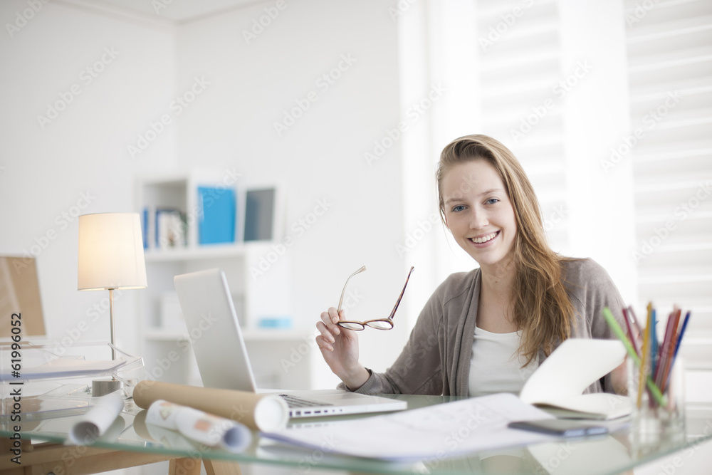 beautiful young woman working on her laptop in her office beautiful young woman working on her laptop in her office