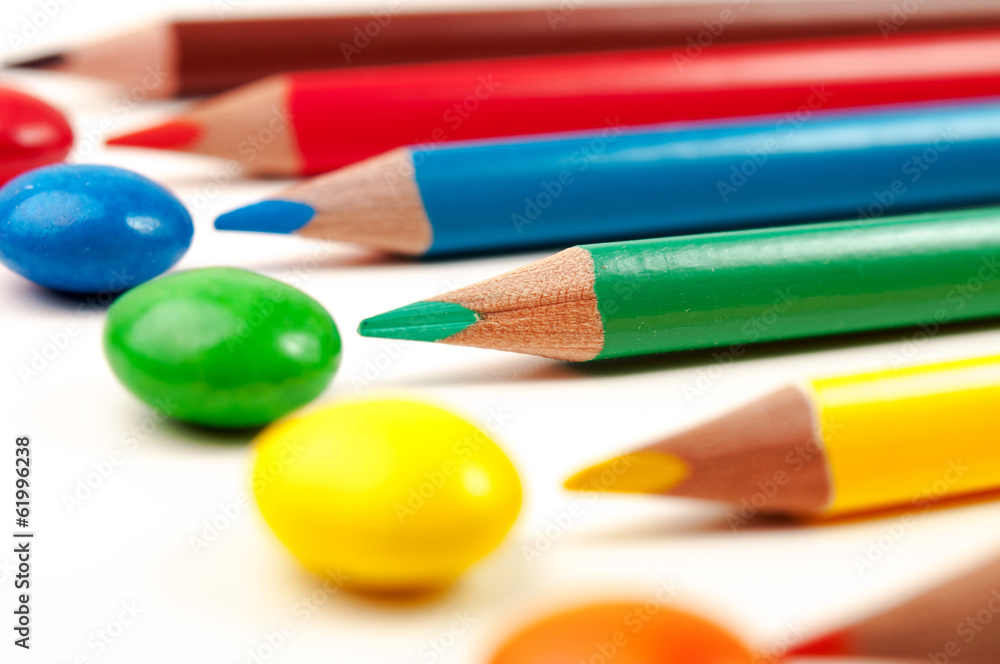 Naklejka premium Some colorign pencils pointing at the same color sweets