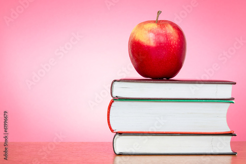 Books and apple with pink background