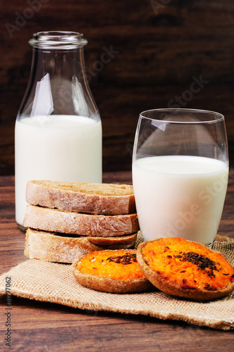 Milk in a bottle and a glass with Sklandrausis and bread photo