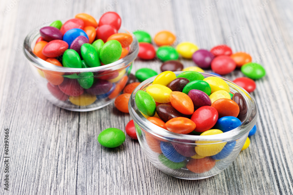 Two bowls with candies and some scattered around Two bowls with candies and some scattered around