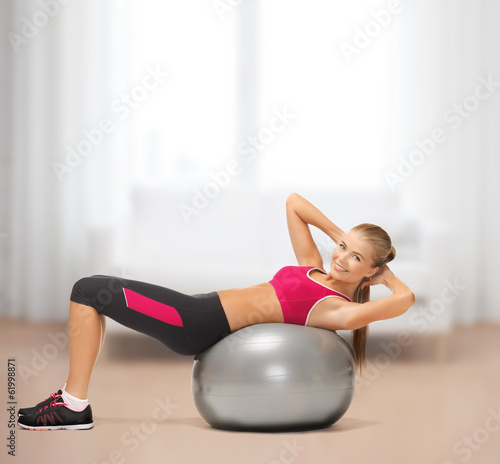 smiling woman with fitness ball at home