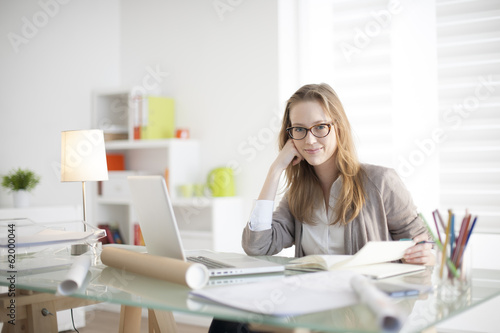 beautiful young woman sitting at her desk in the workplace