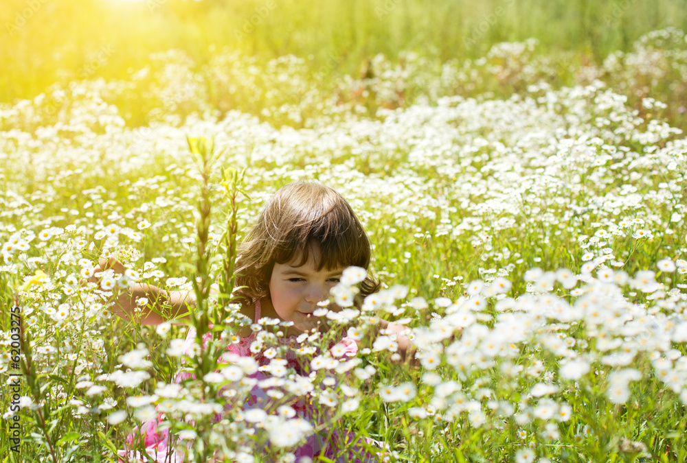 Happy little girl on the flower meadow in sunny day Happy little girl on the flower meadow in sunny day