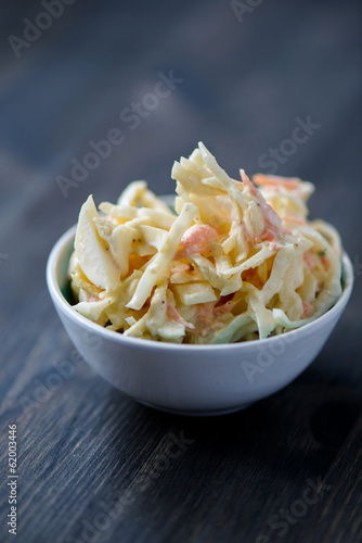 Coleslaw in a bowl on a wooden table