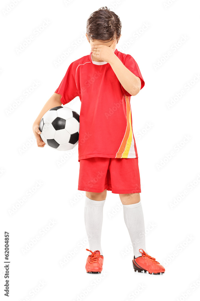 Full length portrait of a sad boy with soccer ball