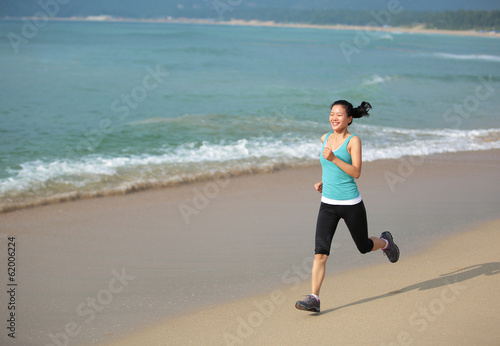 woman runner running on beach