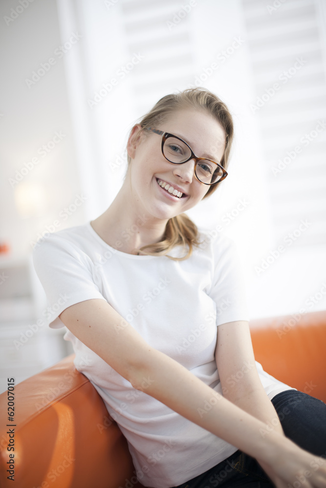 Beautiful young woman sitting in couch at home Beautiful young woman sitting in couch at home
