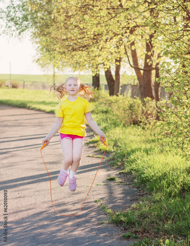 girl jumping over a skipping rope girl jumping over a skipping rope