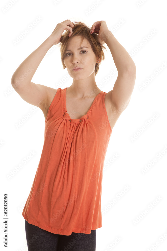 Latin woman orange shirt stand hands in hair Latin woman orange shirt stand hands in hair