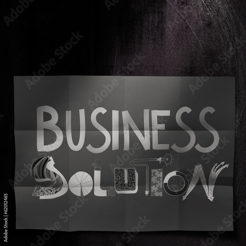 design word BUSINESS SOLUTION on dark crumpled paper and texture