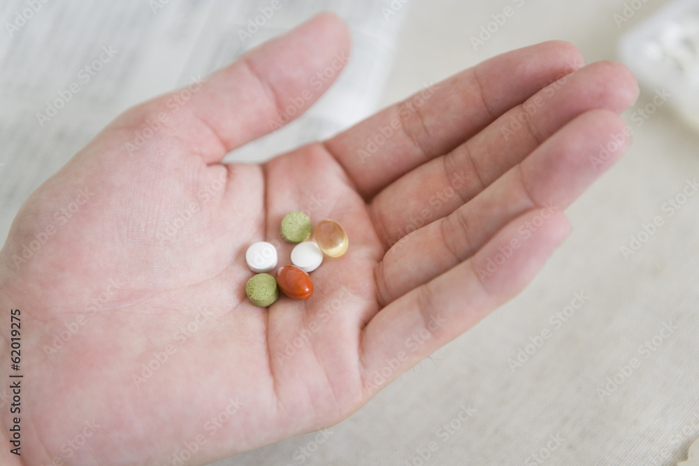hand of man taking supplement in his hand hand of man taking supplement in his hand