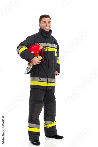 Firefighter posing with helmet under his arm