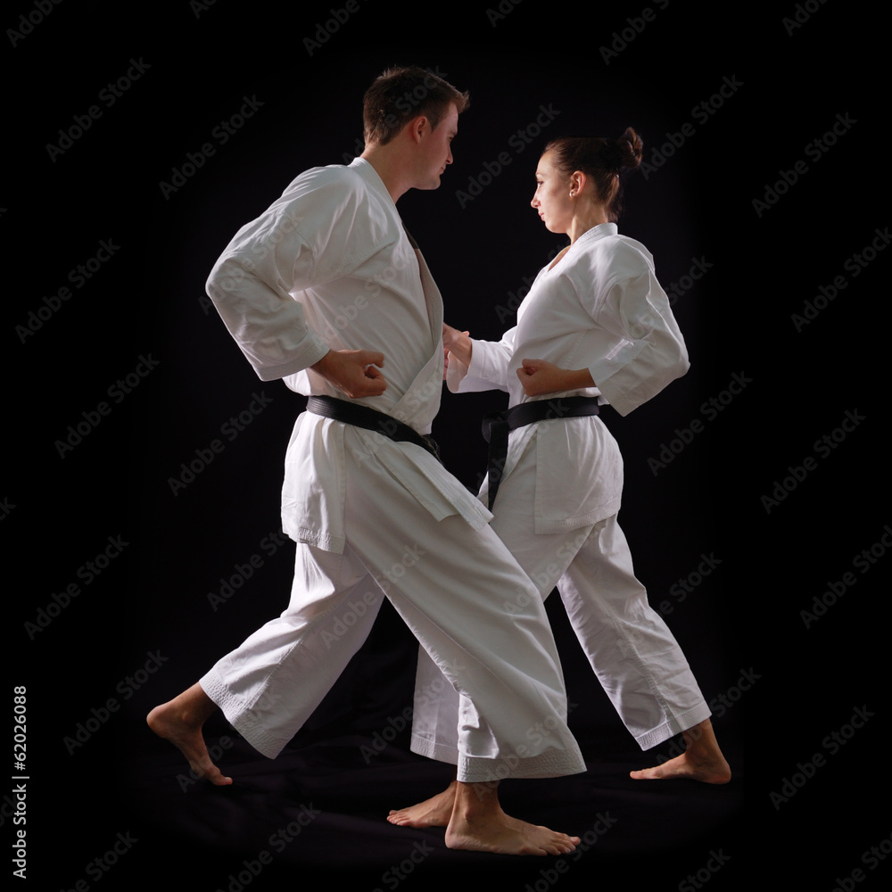 fighting karate couple, man and woman with black belts - champio fighting karate couple, man and woman with black belts - champio