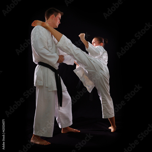 fighting karate couple, man and woman with black belts - champio