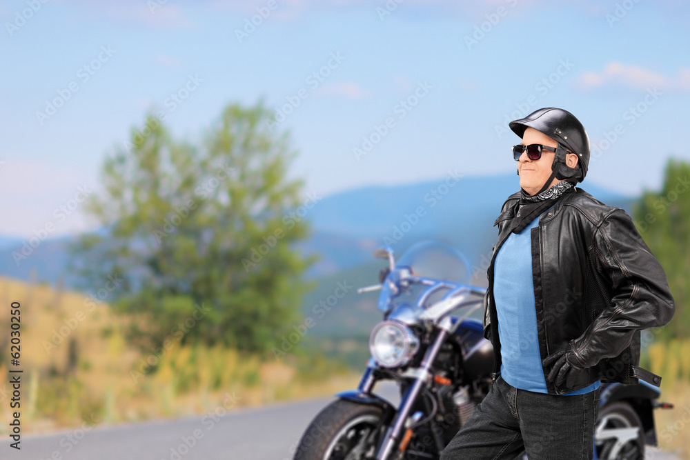 Fototapeta premium Mature biker walking in front of his motorbike