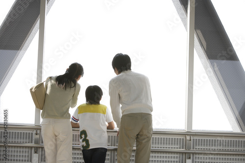 Photography family standing by window and looking outside