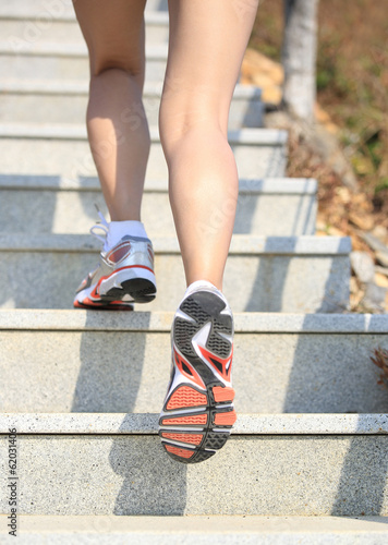 fitness woman legs running up on mountain stairs to peak