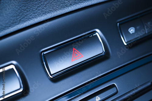 Vehicle hazard warning flashers button with red triangle.
