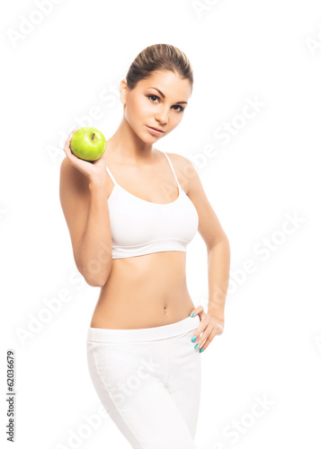 A fit and beautiful girl with an apple isolated on white