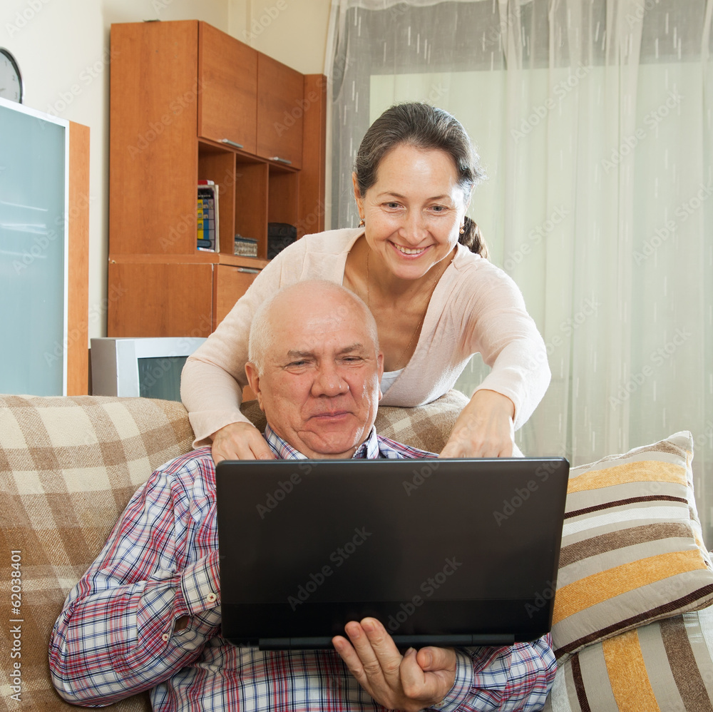 gray-haired man and mature woman working at laptop gray-haired man and mature woman working at laptop